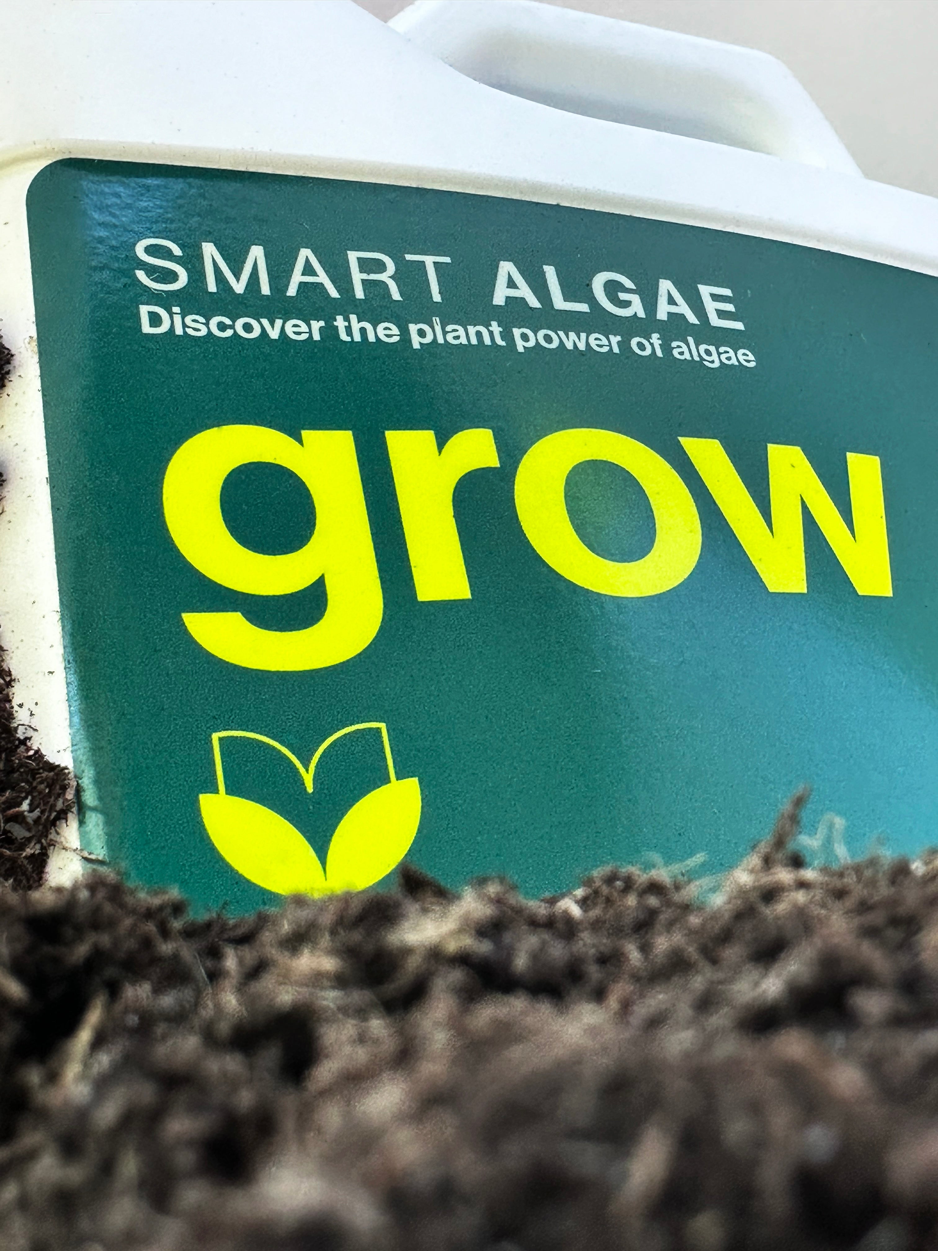 A white gallon container labeled 'SmartAlgae grow' indicating it is a product for rapid and healthy plant growth for both indoor and outdoor plants. Natural Algae bio-stimulant